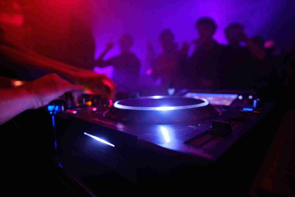 Mesa de mezclas en una discoteca y unas manos a los platos
