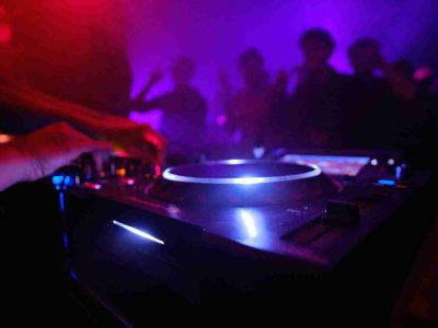 Mesa de mezclas en una discoteca y unas manos a los platos
